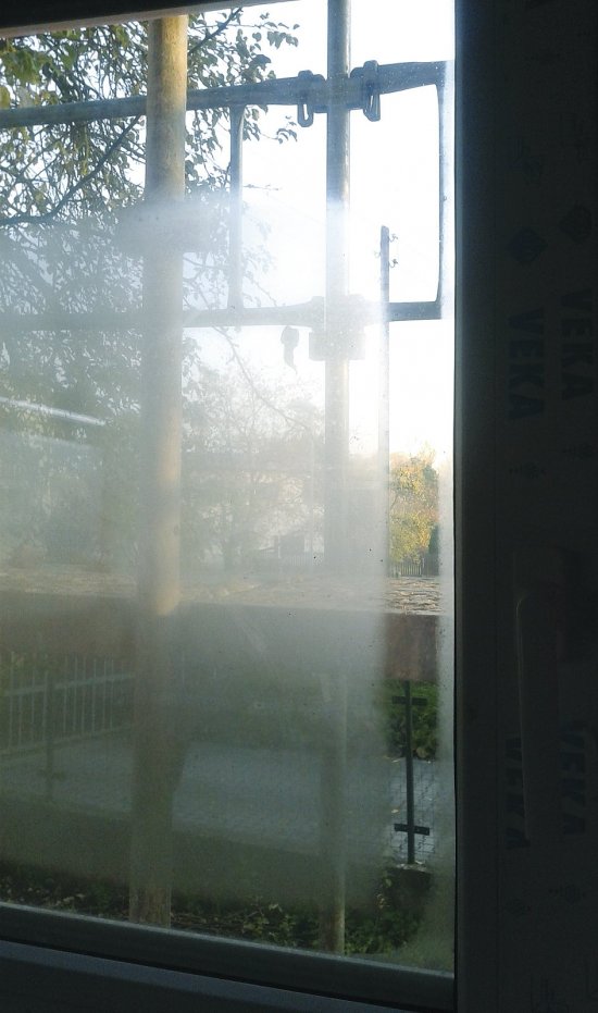 Okno z interiérovej strany v novostavbe s vysokou vlhkosťou, október 2015 ráno. Orosenie je zjavné z obidvoch strán. Na vnútornej strane sa zasklenie (trojsklo) rosí pozdĺž okenného krídla, na vonkajšej strane sú miesta priľahlé k rámu okna a pod nadpražím je naopak centrálna časť suchá a zarosená. V miestnosti, ktorá má bežnú relatívnu vlhkosť cca 50 % by vnútorné rosenie nenastalo.