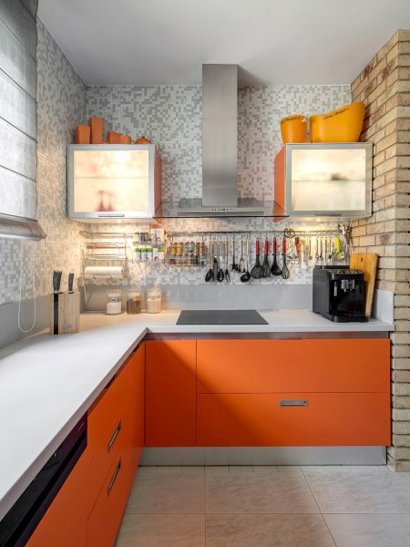 Prakticky zariadený kuchynský kút v kontrastnej oranžovej farbe.