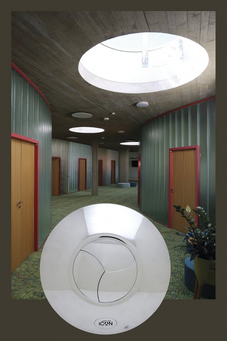 Namiesto bežného ventilátoru sa jedná o dizajnový kruhový disk s trojlistou clonou, ktorá sa pri zapnutí otvorí a po vyvetraní opäť sama zatvorí. Na pozadí fotografie priestor Gallaudent centra. 