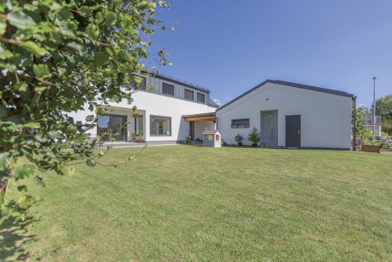 Vikiere v podkroví sú obložené hliníkovým plechom. Garáž s dielňou plynule nadväzuje na dom.