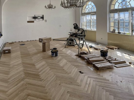 Masívne dubové parkety 22 × 75 × 500 mm boli kladené do stromčeka. Na lepenie slúžilo prémiové parketové lepidlo UZIN MK 200.