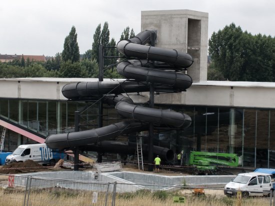 Nové písecké kúpalisko postupne nadobúda svoju finálnu podobu. Zvonku je najnápadnejším prvkom čierny tobogan, ktorý sa vinie pozdĺž presklenej steny budovy. Zdroj: Mgr. Zdeněk Svoboda