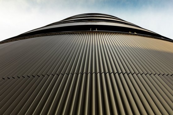 Fasádu pokrýva približne 1 100 m² lisovaných profilov PREFA v odtieni strednej bronz C33.
