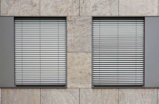 Exteriérové tienenie v reflexnej striebornej farbe a svetlo sfarbenej fasády efektívne bránia prehrievaniu vnútorných priestorov objektu. (Autor: elxeneize, Shutterstock)