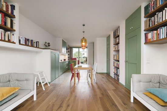 Byty sú ladené do neutrálnych farebných odtieňov a doplnené o výraznejšie detaily, akými sú zelené dvere či nábytok na fotografii