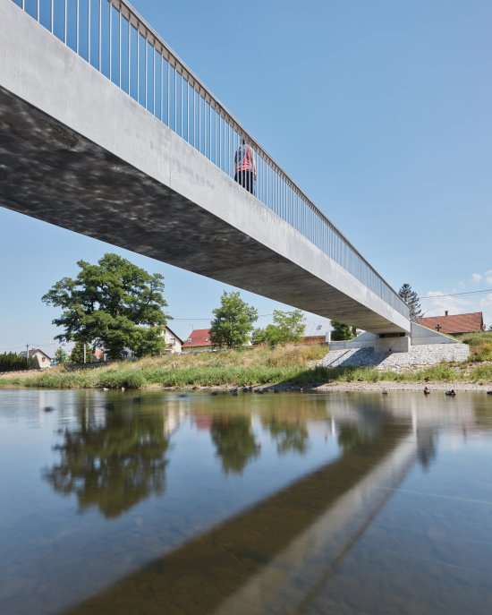 Konštrukčným materiálom lávky cez rieku Lubinu v Příboře bol UHPC. Prostý nosník o rozpätí 35 metrov je vytvorený zopnutím piatich dvojkomorových segmentov. Konštrukcia má unikátny štíhlostný pomer výšky k dĺžke 1 : 44 a je prvá svojho druhu na českom území. Foto: BoysPlayNice