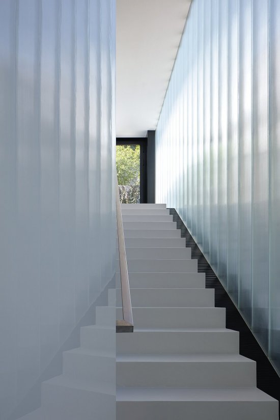 Nepriehľadná stena z U profilových sklenených dielcov oddeľuje vnútorné schodisko od vonkajšieho.